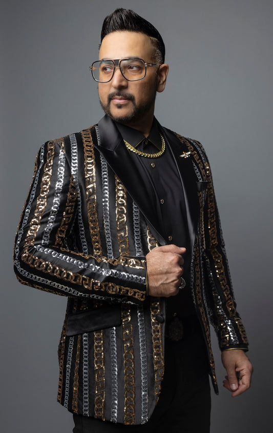 Men's slim-fit blazer with a satin notch lapel, long sleeves, and two-button closure. The blazer features a unique pattern combining Cuban chain, Greek key, and sequin designs. Made from 100% regenerated fiber.