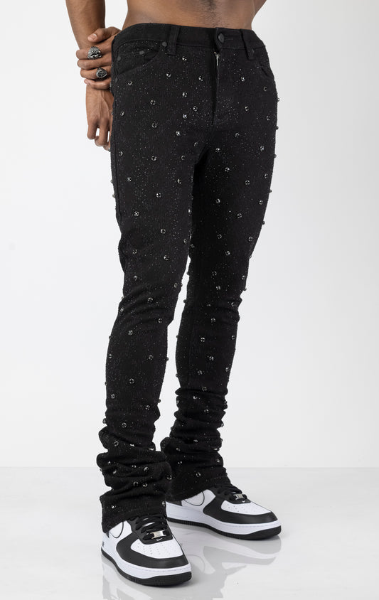 Men's black, tapered-fit jeans with a luxurious cotton-blend fabric (98% cotton, 2% elastane) and custom hardware. The jeans feature subtle laser distressing throughout, delicate diamond embellishments, and a five-pocket design. They stack comfortably above the ankle.