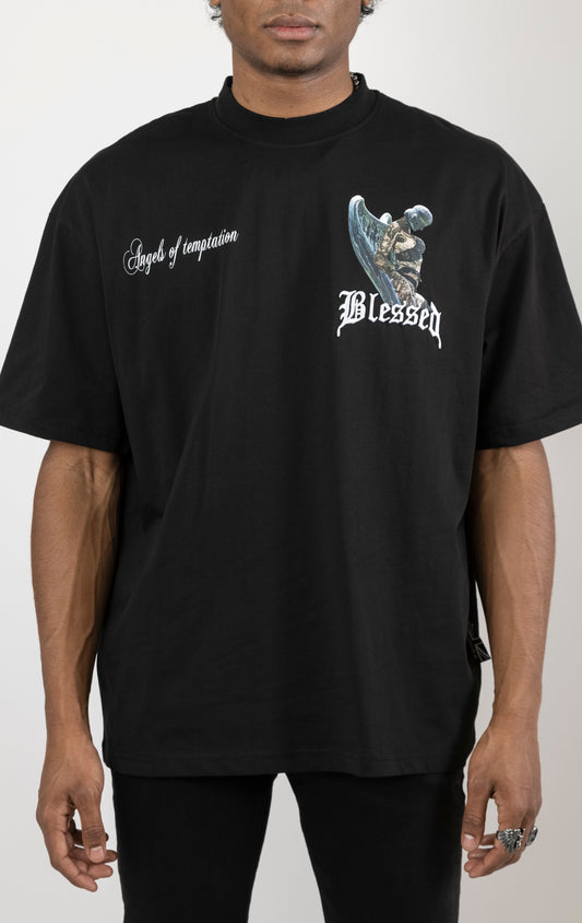Men's boxy fit t-shirt in black. The shirt features dropped shoulders, longer sleeves, and a wide, fitted neck rib. It has "Angels of Temptation" printed on the front and back with 3D "blessed" embroidery on the chest and back.  Made from 100% cotton jersey (190gsm).  A "blessed" slogan is printed on the inner neck binding.