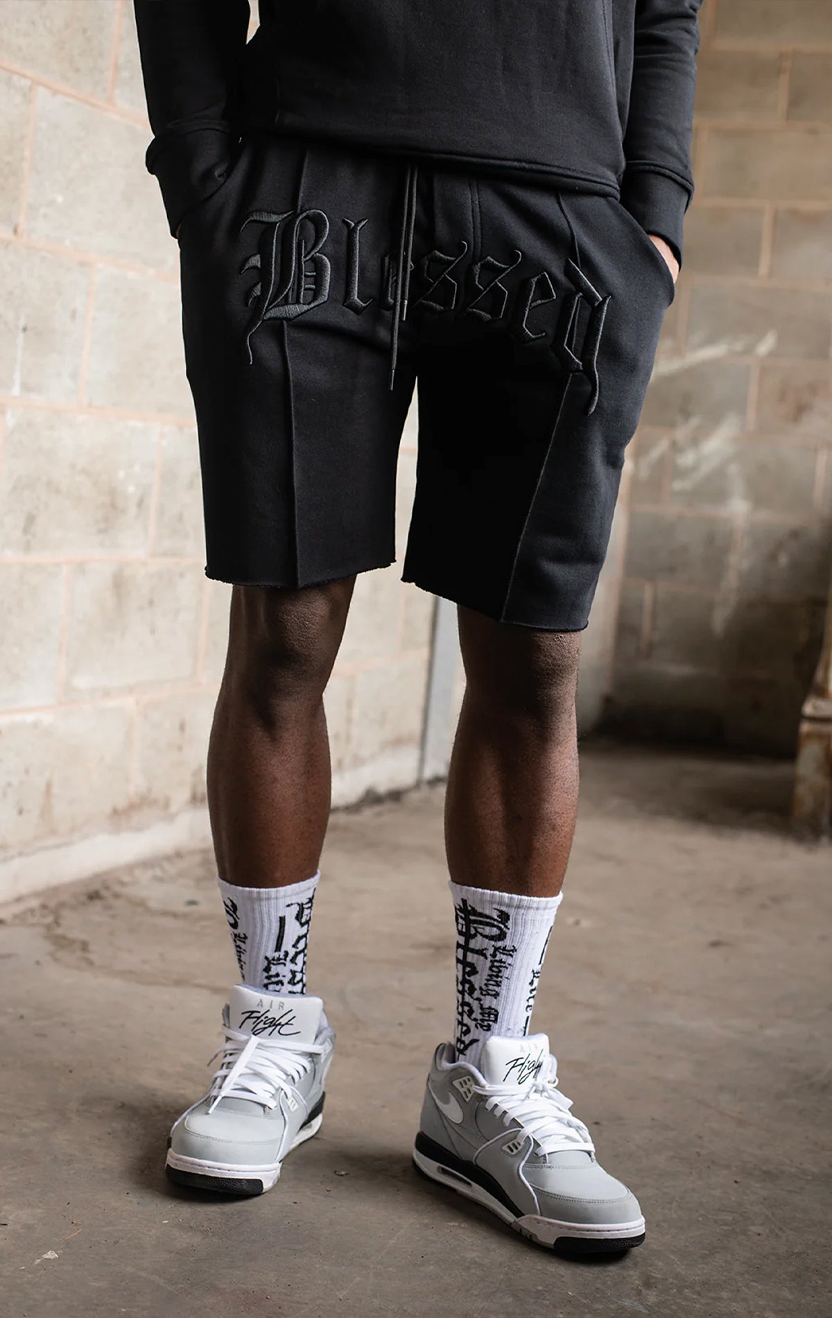 Men's casual, straight-leg shorts in black. The shorts feature a 100% cotton fabric, an arched 3D embroidered 
