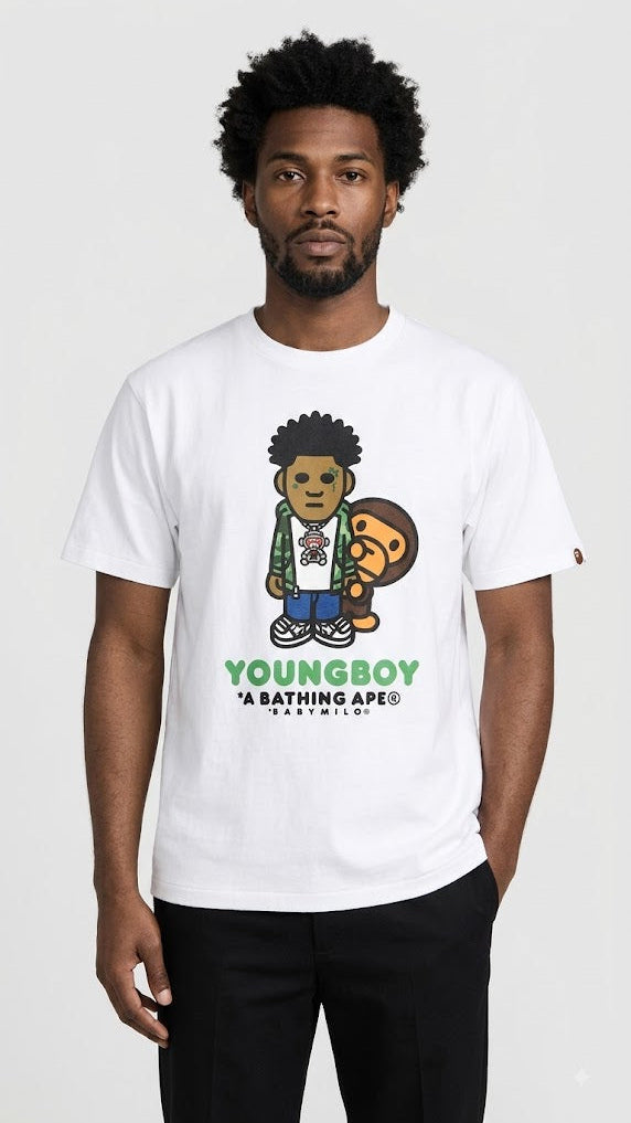 A man wearing a white A Bathing Ape Youngboy t-shirt with a cartoon graphic of Youngboy holding a BAPE ape head, set against a plain light gray background.
