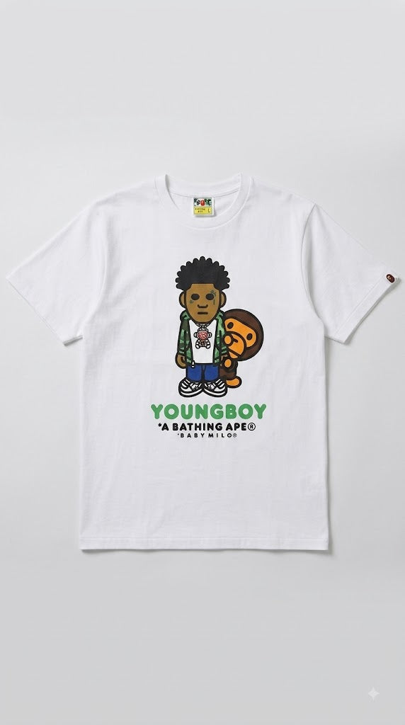 A white short-sleeve graphic t-shirt featuring a cartoon illustration of a boy holding a BAPE head, with 'YOUNGBOY' and 'A BATHING APE' printed below in green and black.