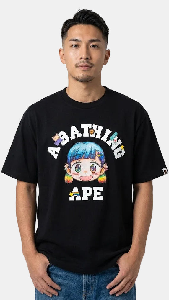 A man wearing a black A Bathing Ape graphic t-shirt with a colorful cartoon character and text on the front, paired with blue jeans, against a light gray background.