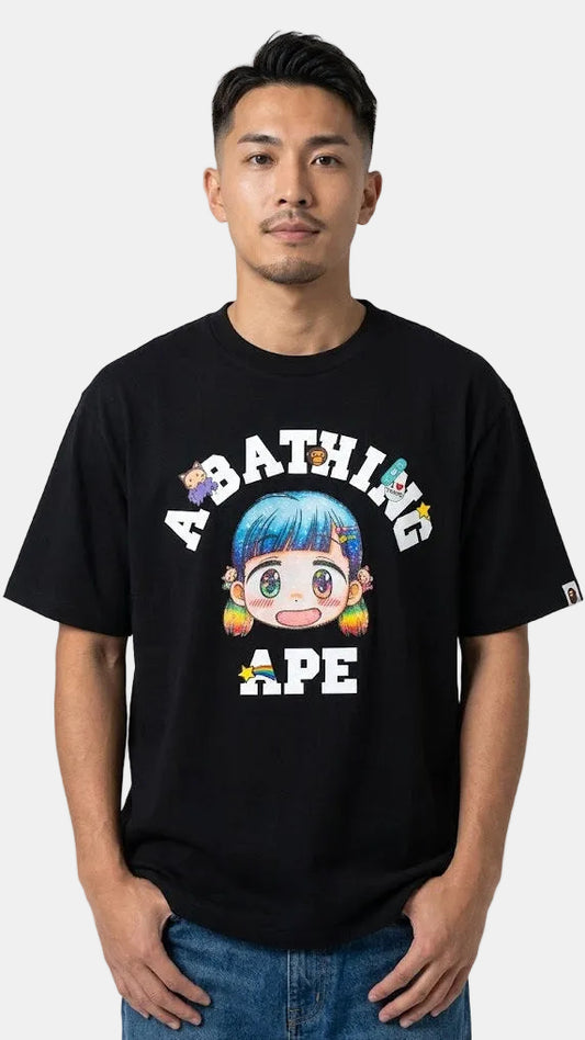 A man wearing a black A Bathing Ape graphic t-shirt with a colorful cartoon character and text on the front, paired with blue jeans, against a light gray background.
