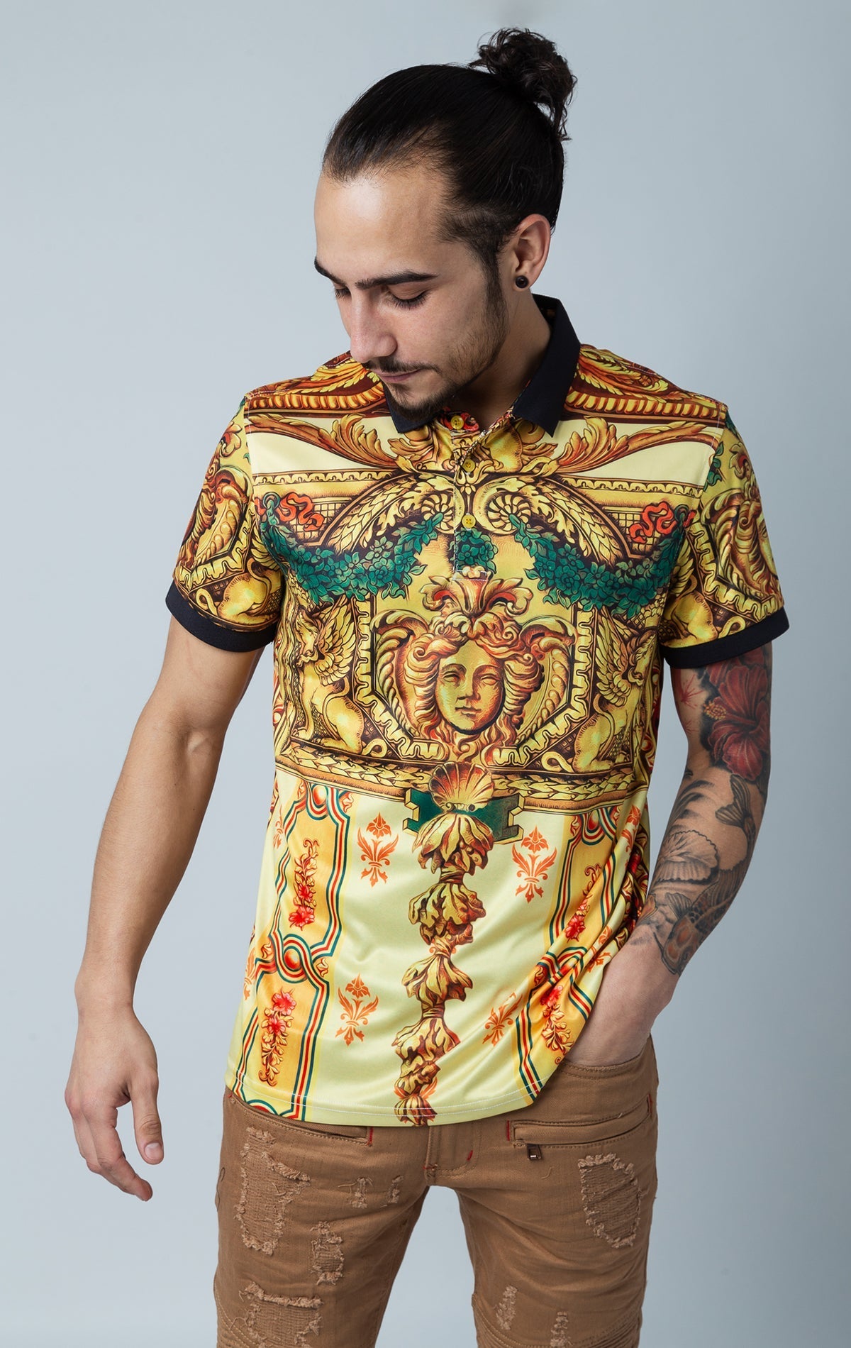 Men's printed Medusa and floral short-sleeve polo shirt with a Baroque design, contrasting collar, and three-button closure in gold and black.