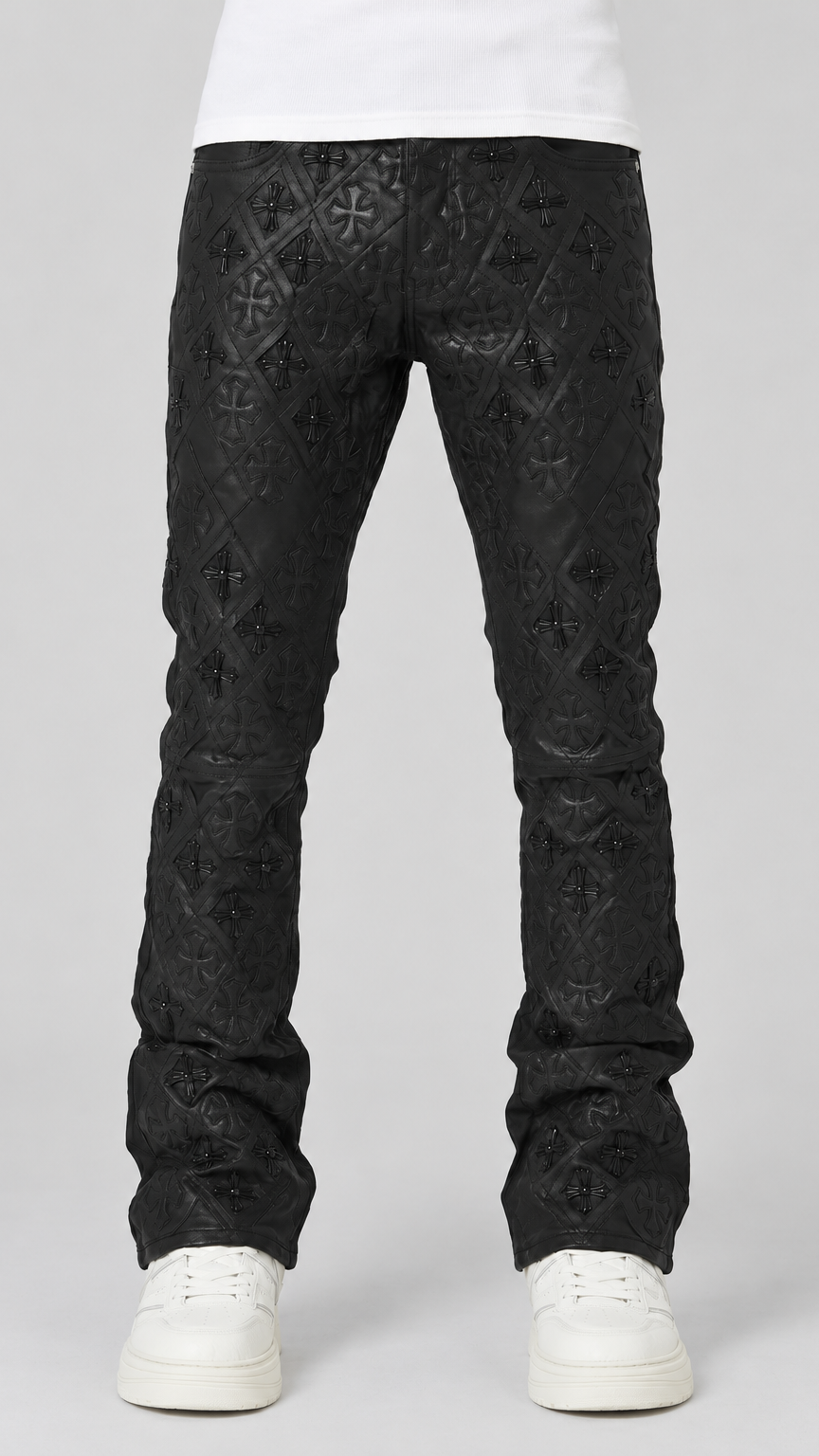 Black textured jeans with an allover embossed geometric pattern, shown on a model from the waist down wearing white sneakers against a light gray studio background.