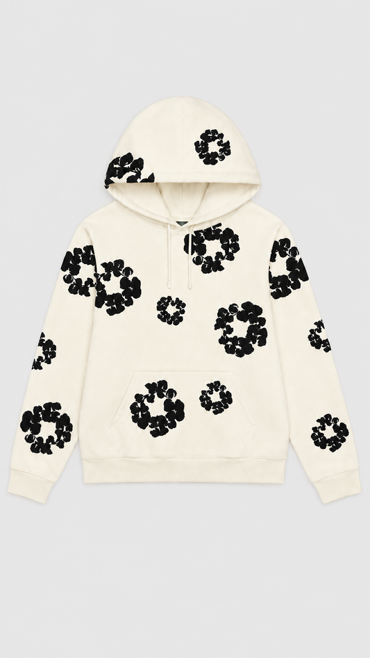An off-white hooded sweatshirt with black circular floral patterns, displayed flat against a light gray background.