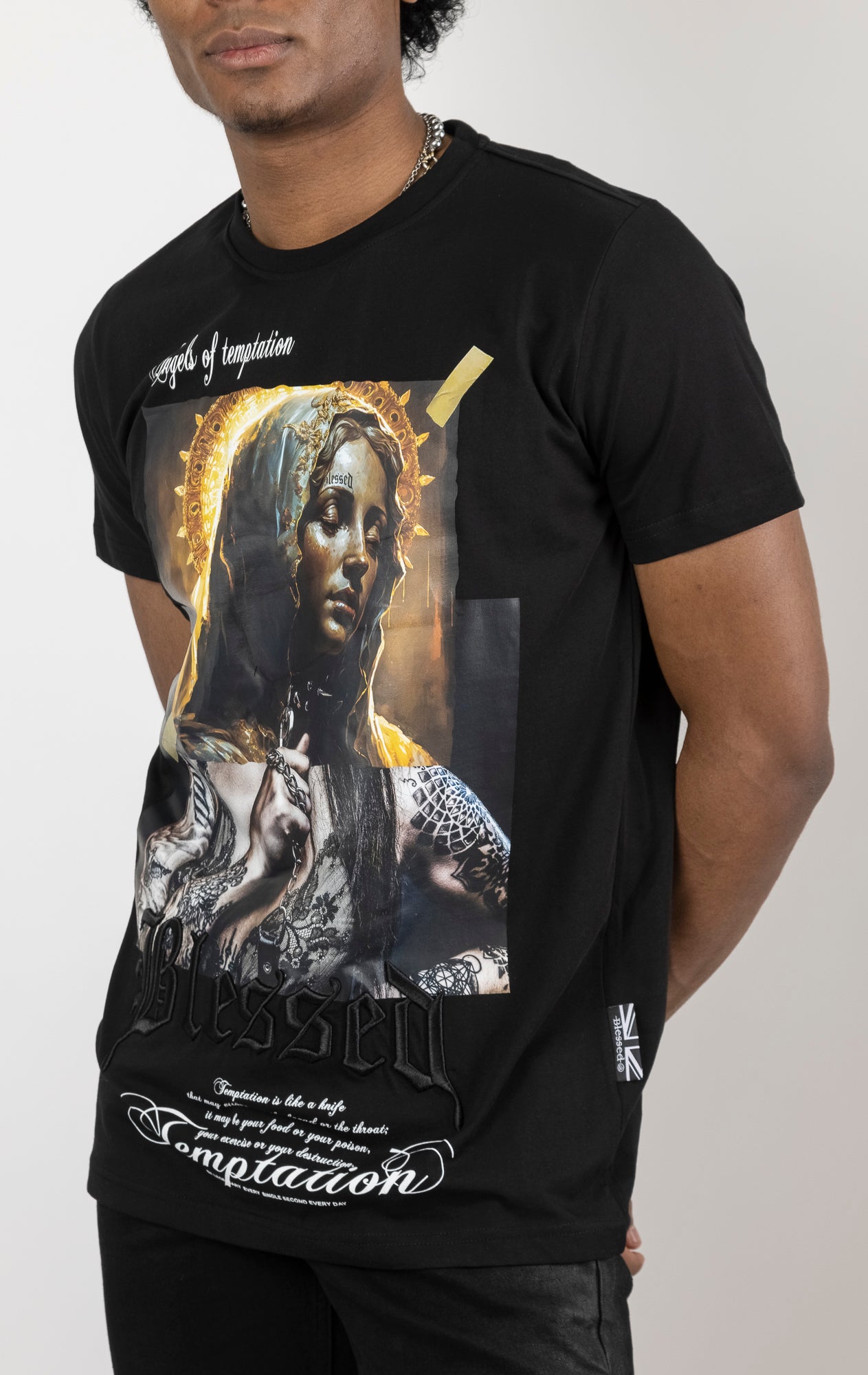 Black Men's regular fit t-shirt in a variety of colors. The shirt features a slightly elongated sleeve, a fitted neckline, and a straight body. It has a "Temptation" front print with 3D embroidery. Made from 100% cotton jersey (190gsm). A "blessed" slogan is printed on the inner neck binding and a woven side seam tab with "blessed" is also included.
