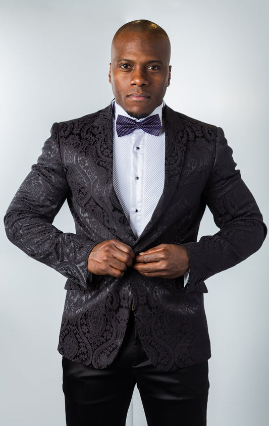 Men's slim-fit blazer in black. The blazer features a paisley patterned poly fabric, peak lapels, one-button closure, and double side vents. 