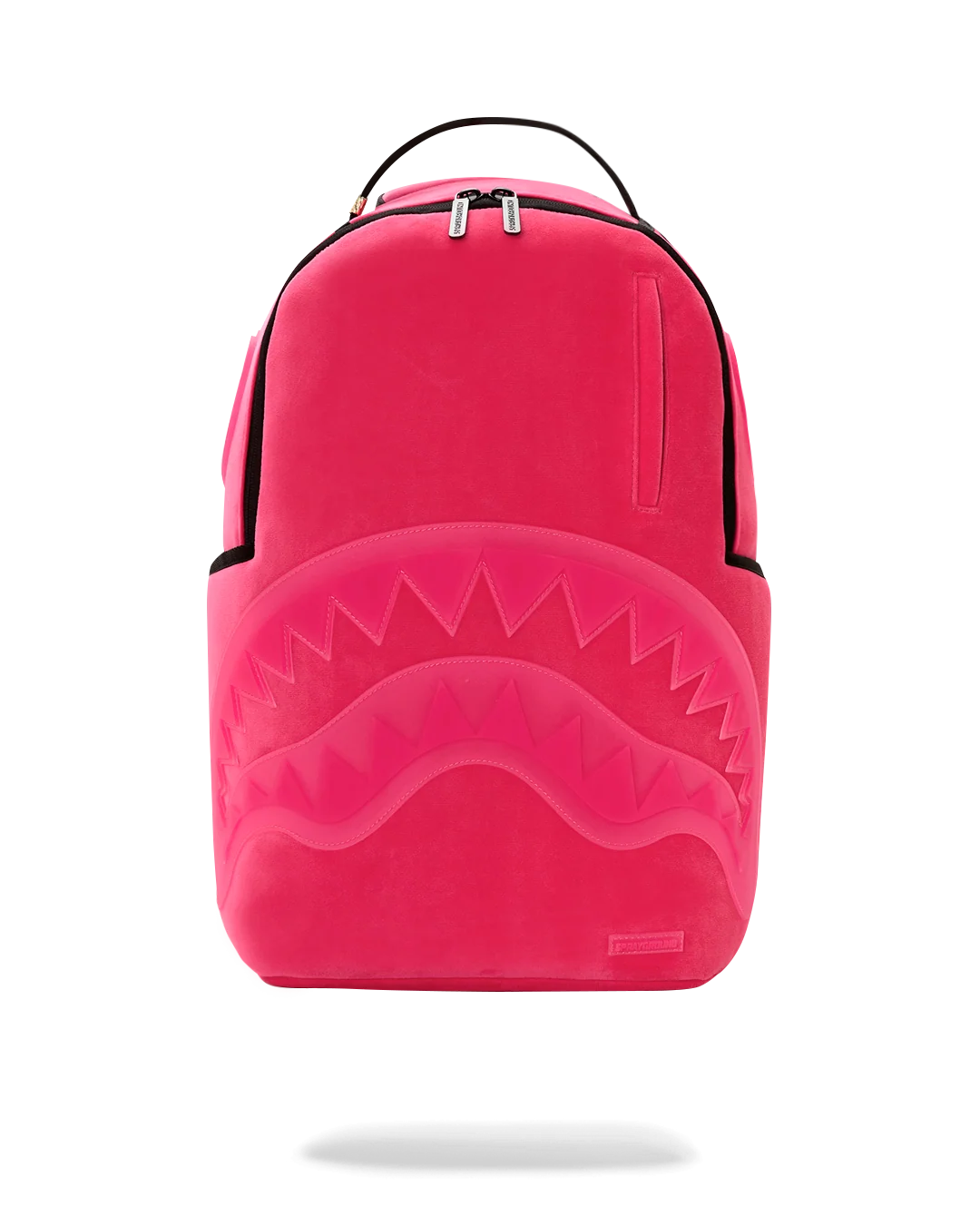 A bright pink Sprayground  shark backpack with a large embossed shark mouth design on the front, black trim, and a top carry handle, shown against a plain white background.