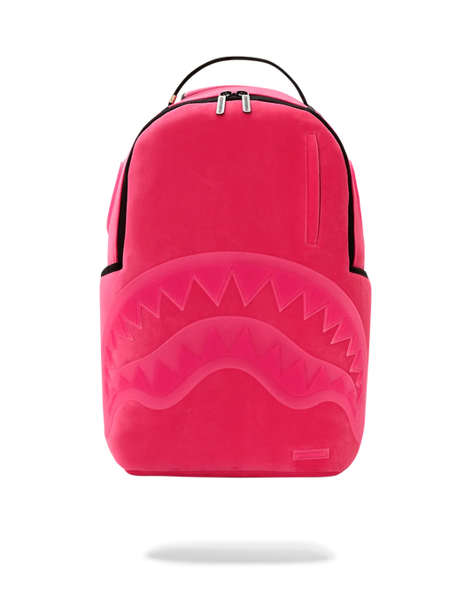 A bright pink Sprayground  shark backpack with a large embossed shark mouth design on the front, black trim, and a top carry handle, shown against a plain white background.