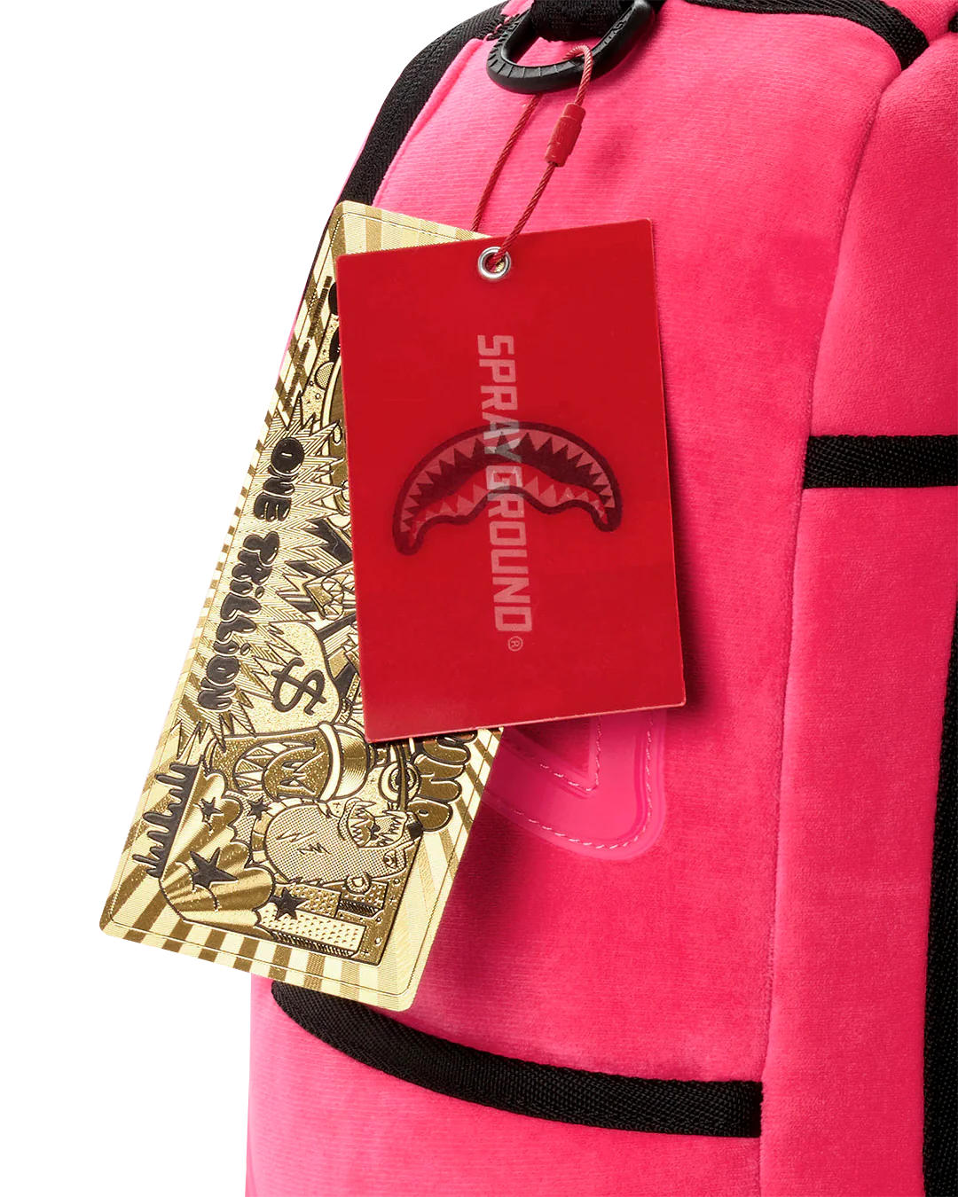 A close-up of a bright pink backpack with black trim, featuring a red Sparx Ground hangtag with a shark logo and a gold patterned paper tag.