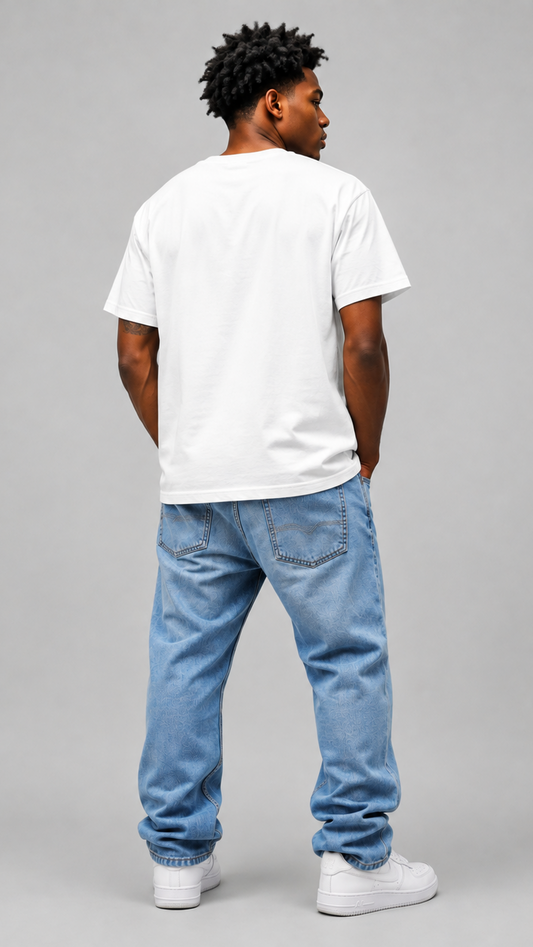 A man viewed from behind wearing a plain white crewneck t-shirt, light blue jeans, and white sneakers, standing against a solid gray studio background.