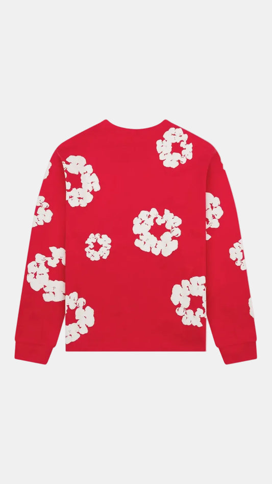 A red long-sleeve crewneck sweatshirt featuring a white abstract floral or circular pattern printed all over it, shown against a plain light gray background.