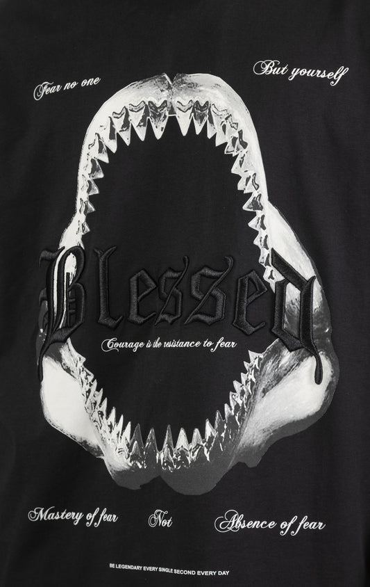 Men's boxy fit t-shirt in black. The shirt features dropped shoulders, longer sleeves, and a wide, fitted neck rib. It has a "Courage" front print with 3D embroidery. Made from 100% cotton jersey (190gsm). A "blessed" slogan is printed on the inner neck binding.