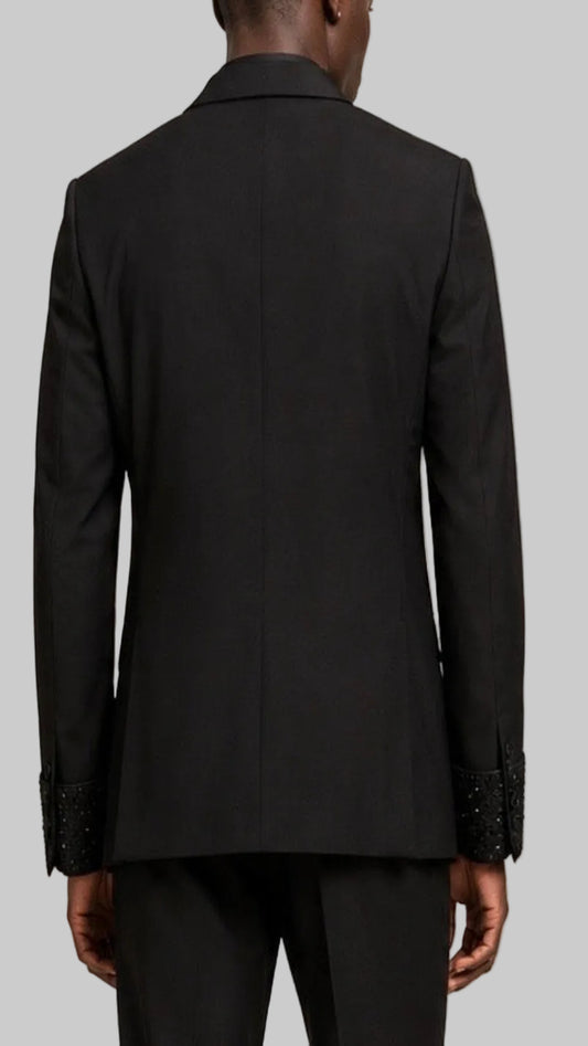 Black suit jacket with embellished cuffs on a grey background