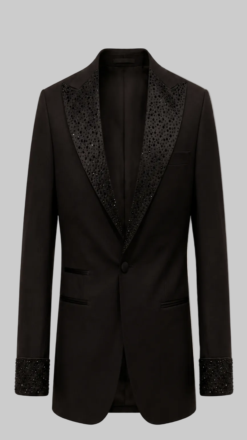 A black single-breasted tuxedo jacket with ornate black beaded lapels and matching beaded cuff trim, shown against a solid pale pink background.