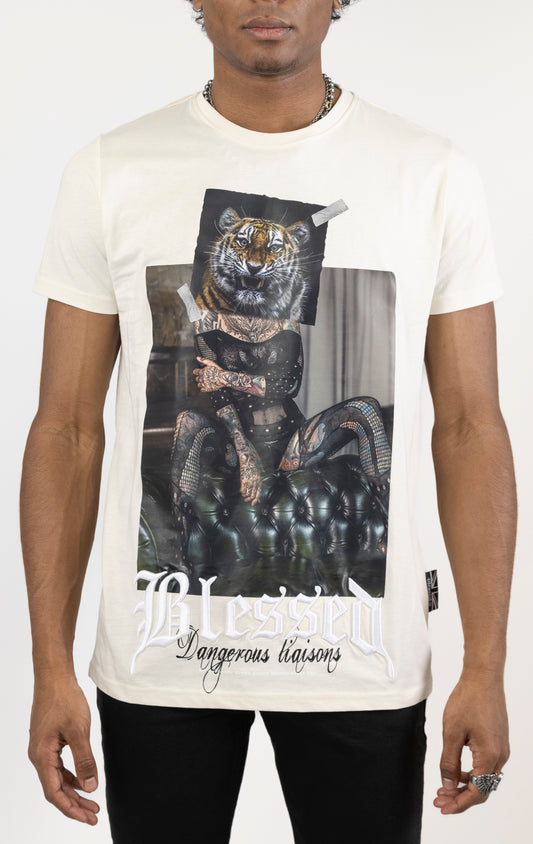 Men's regular fit t-shirt in eggshell color. The shirt features a slightly elongated sleeve, a fitted neckline, and a straight body. It has a "Dangerous Liaisons" front print with 3D embroidery. Made from 100% cotton jersey (190gsm). A "blessed" slogan is printed on the inner neck binding and a woven side seam tab with "blessed" is also included.