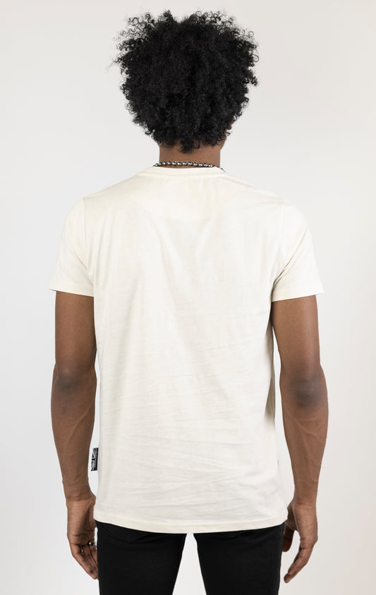 Men's regular fit t-shirt in eggshell color. The shirt features a slightly elongated sleeve, a fitted neckline, and a straight body. It has a "Dangerous Liaisons" front print with 3D embroidery. Made from 100% cotton jersey (190gsm). A "blessed" slogan is printed on the inner neck binding and a woven side seam tab with "blessed" is also included.