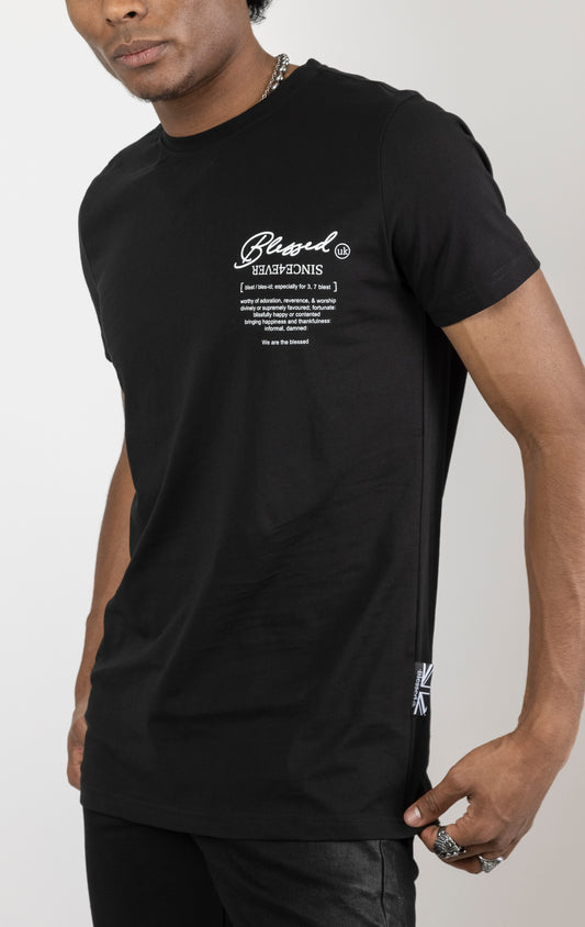 Men's regular fit t-shirt in black. The shirt features a slightly elongated sleeve, a fitted neckline, and a straight body. It has a "Forever a Saint, Never a Snake" digital print on the back with 3D "blessed" embroidery. Made from 100% cotton. A "blessed" slogan is printed on the inner neck binding and a woven side seam tab with "blessed" is also included. The front features a "blessed" with a strikethrough design and the back neck features a signature "blessed" script print.