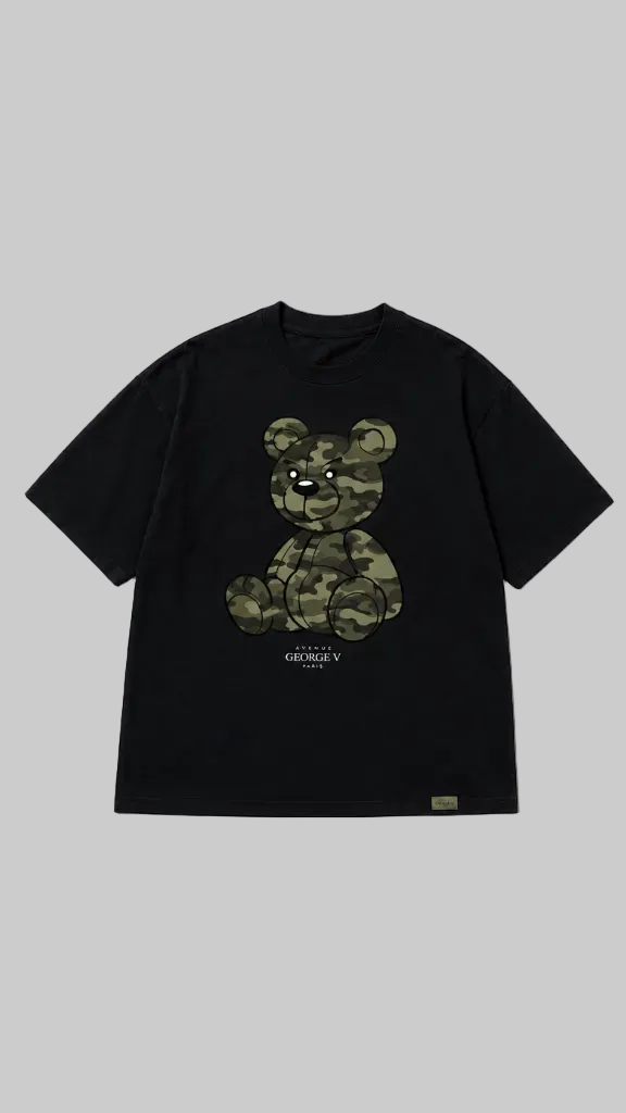 Black short-sleeve T-shirt shown from the front on a grey background. The front features a large teddy bear graphic in a green camouflage pattern with small text below.