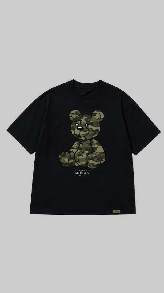 Black short-sleeve T-shirt shown from the front on a grey background. The front features a large teddy bear graphic in a green camouflage pattern with small text below.