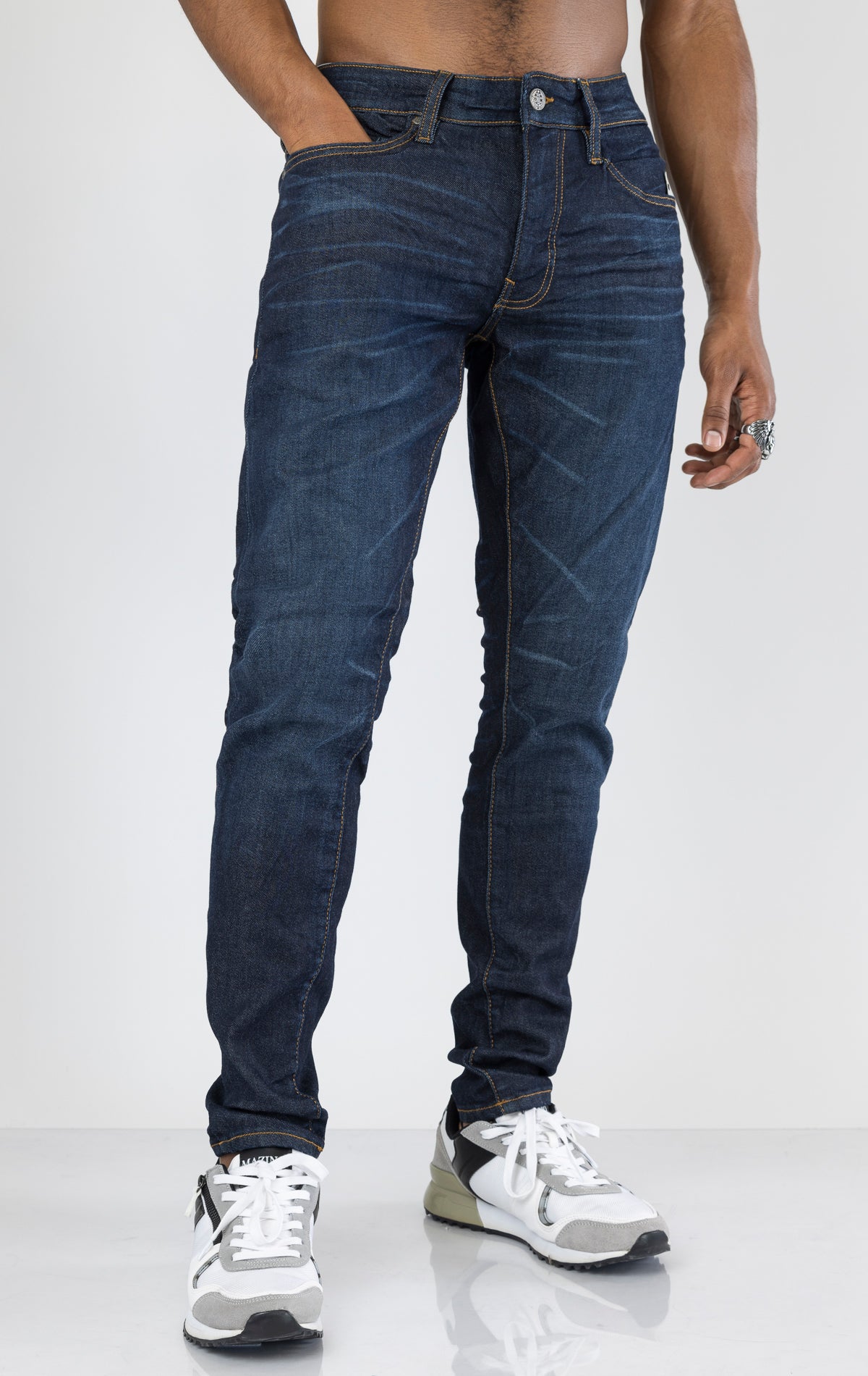 Men's Sean Slim Taper jeans in dark indigo. The jeans feature a regular rise waist, a comfortable fit from waist to thigh, a slim taper from knee to ankle, 3D baked wrinkles for texture, a raw denim look, and are made from a super stretch fabric blend (35% Cotton, 30% Polyester, 34% Tencel and 1% Elastane).
