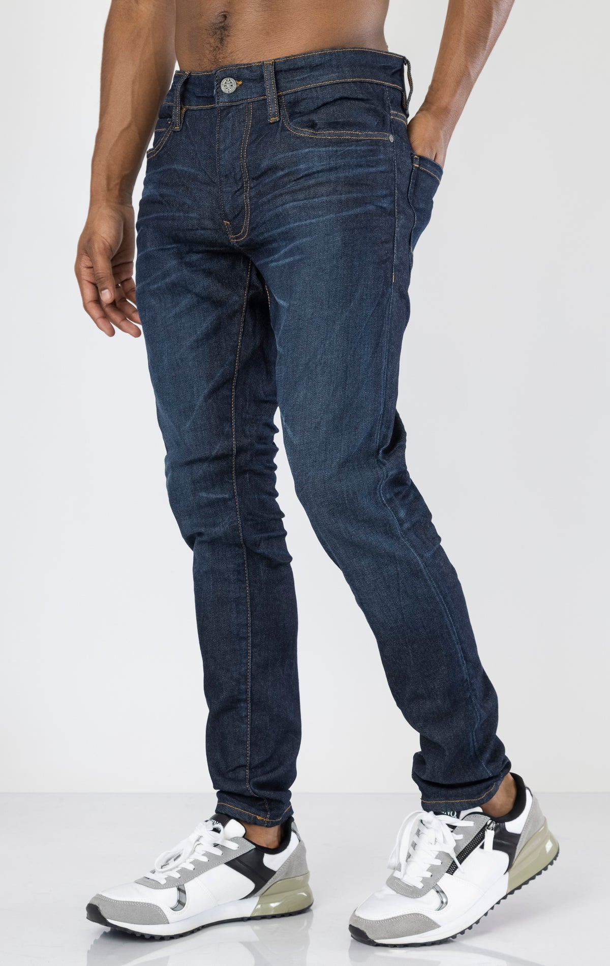 Men's Sean Slim Taper jeans in dark indigo. The jeans feature a regular rise waist, a comfortable fit from waist to thigh, a slim taper from knee to ankle, 3D baked wrinkles for texture, a raw denim look, and are made from a super stretch fabric blend (35% Cotton, 30% Polyester, 34% Tencel and 1% Elastane).