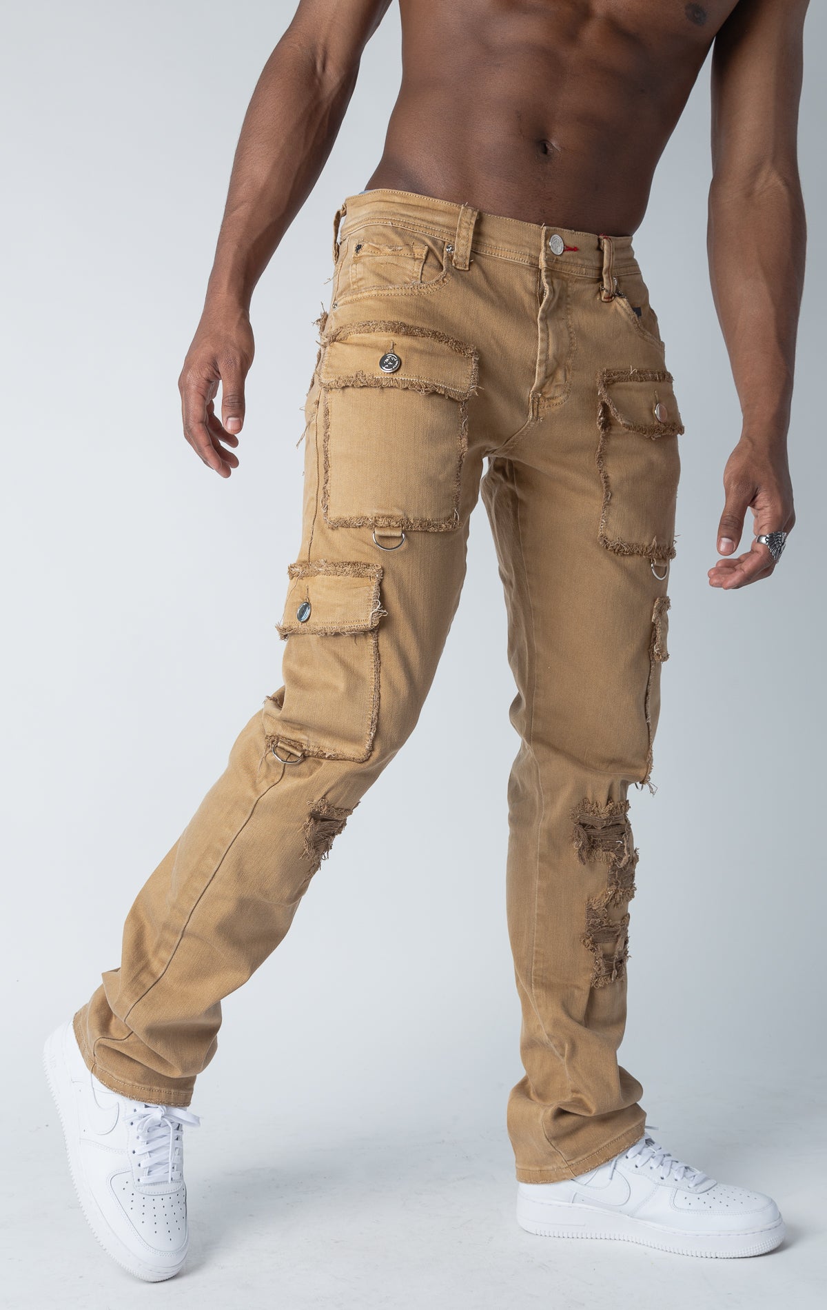 Slim fit, stretch denim cargo jeans with multiple pockets, distressed detailing at the edges, and reinforced stitching.