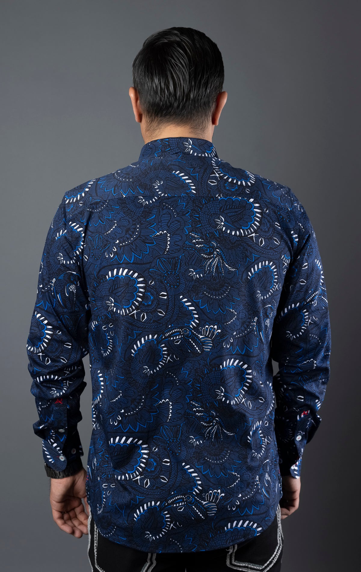 Close-up of a modern-fit dress shirt featuring an angled buttonhole, three buttons grouped together on the front placket, multiple embroidery details, and an elegant ceramic button on the sleeve placket. Canadian designed with performance stretch cotton fabric.