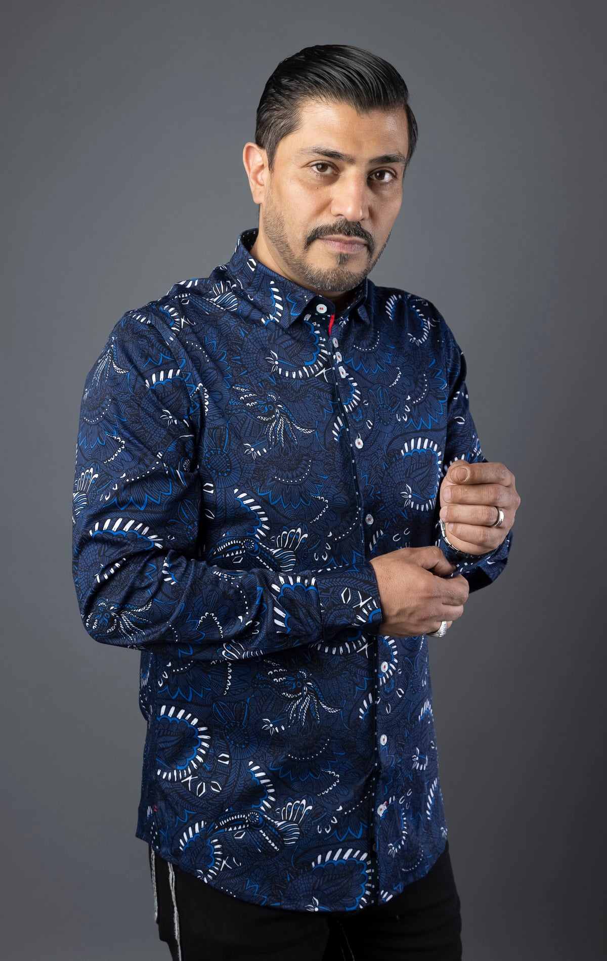 Close-up of a modern-fit dress shirt featuring an angled buttonhole, three buttons grouped together on the front placket, multiple embroidery details, and an elegant ceramic button on the sleeve placket. Canadian designed with performance stretch cotton fabric.