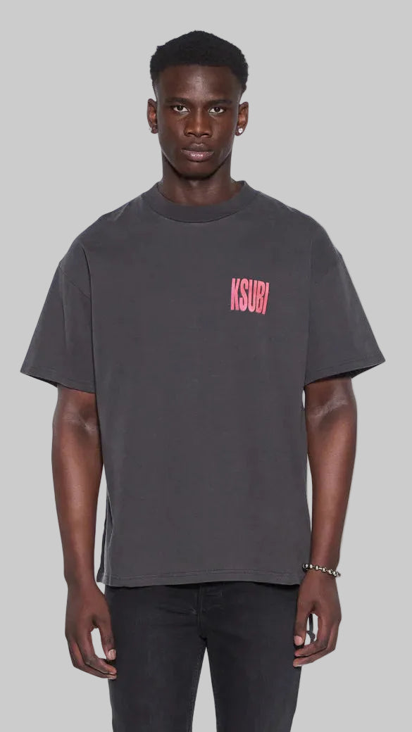 Man wearing a dark gray t-shirt with a red "Ksubi" logo on a grey background