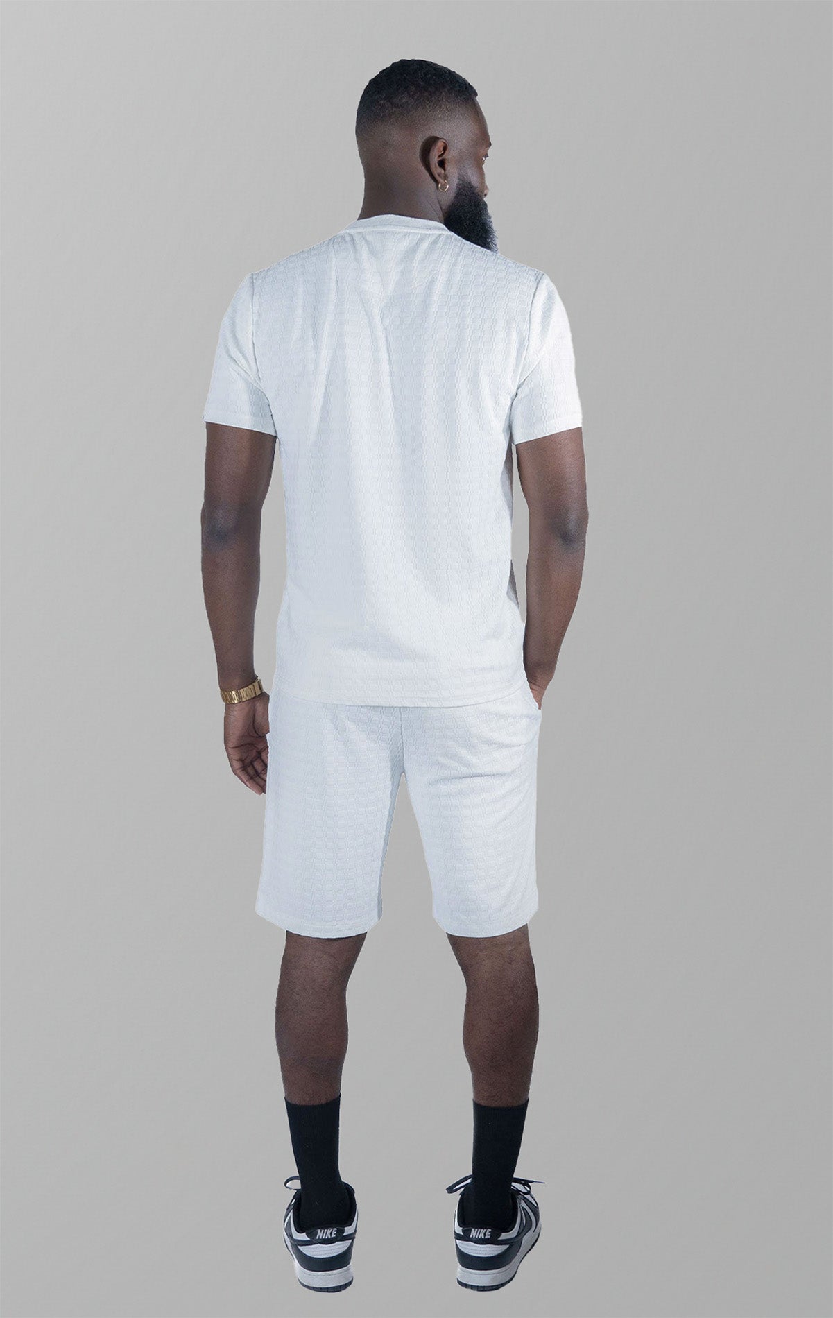 White Modena Knit Tee. Made from a high-quality blend of 95% cotton and 5% spandex for a soft and comfortable feel. Features a unique embossed jacquard fabric with colored blocking for a textured and stylish look. This tee is pre-shrunk and true to size.