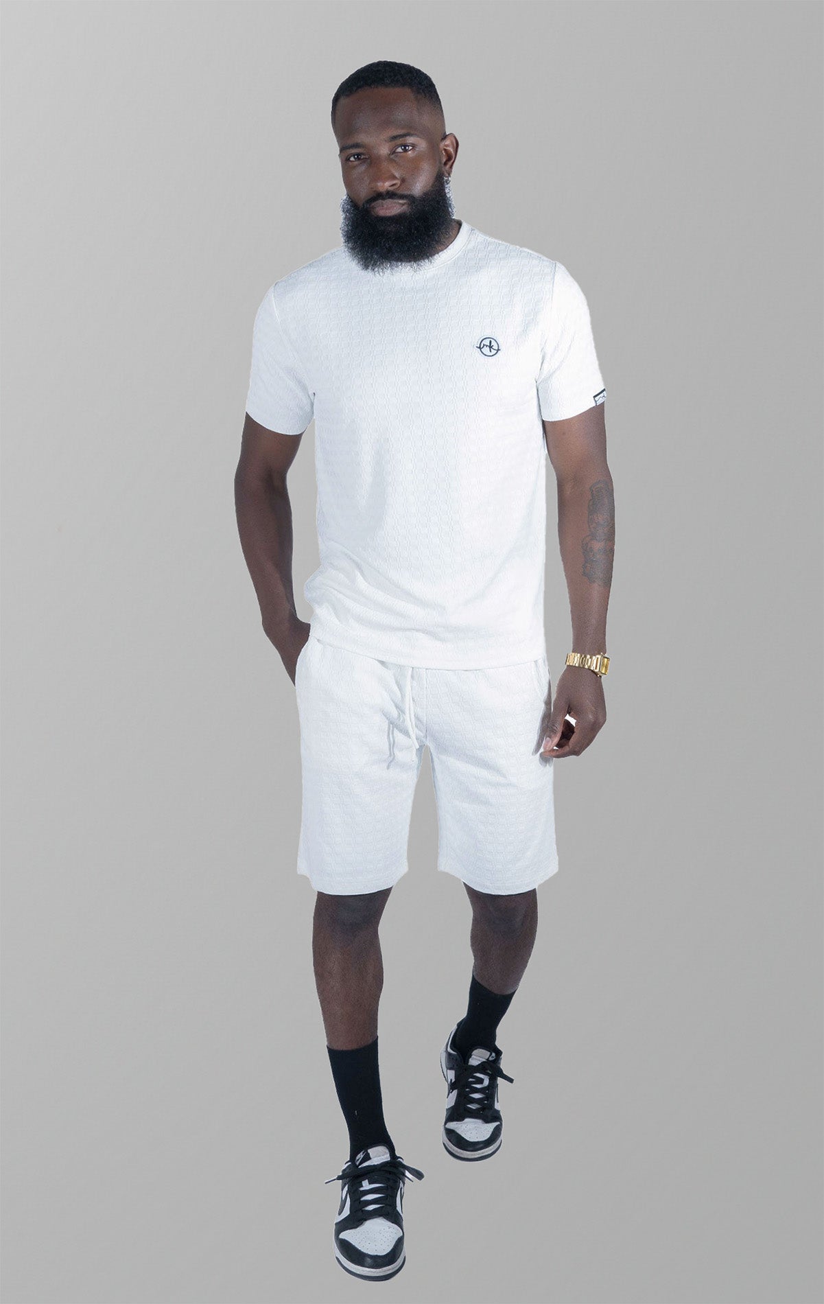White Modena Knit Tee. Made from a high-quality blend of 95% cotton and 5% spandex for a soft and comfortable feel. Features a unique embossed jacquard fabric with colored blocking for a textured and stylish look. This tee is pre-shrunk and true to size.