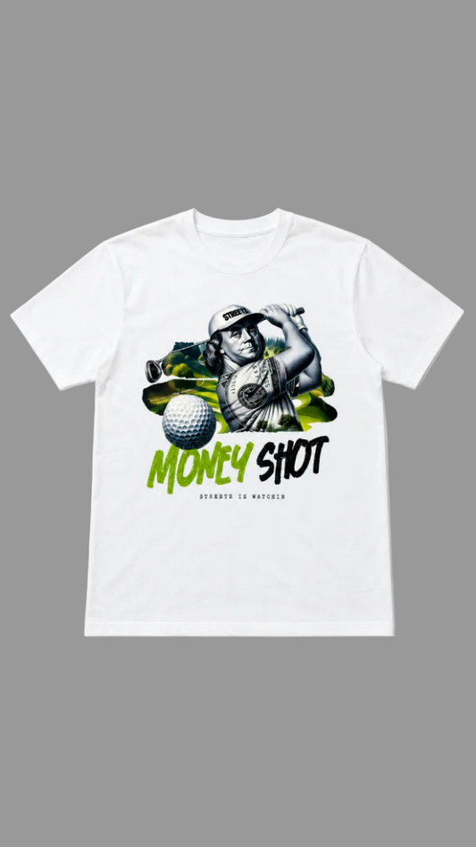 A white short-sleeve crewneck t-shirt featuring a graphic print of a golfer swinging a club, a golf ball, and the text 'MONEY SHOT' in green and black, with 'STREETZ IZ WATCHIN' printed below.