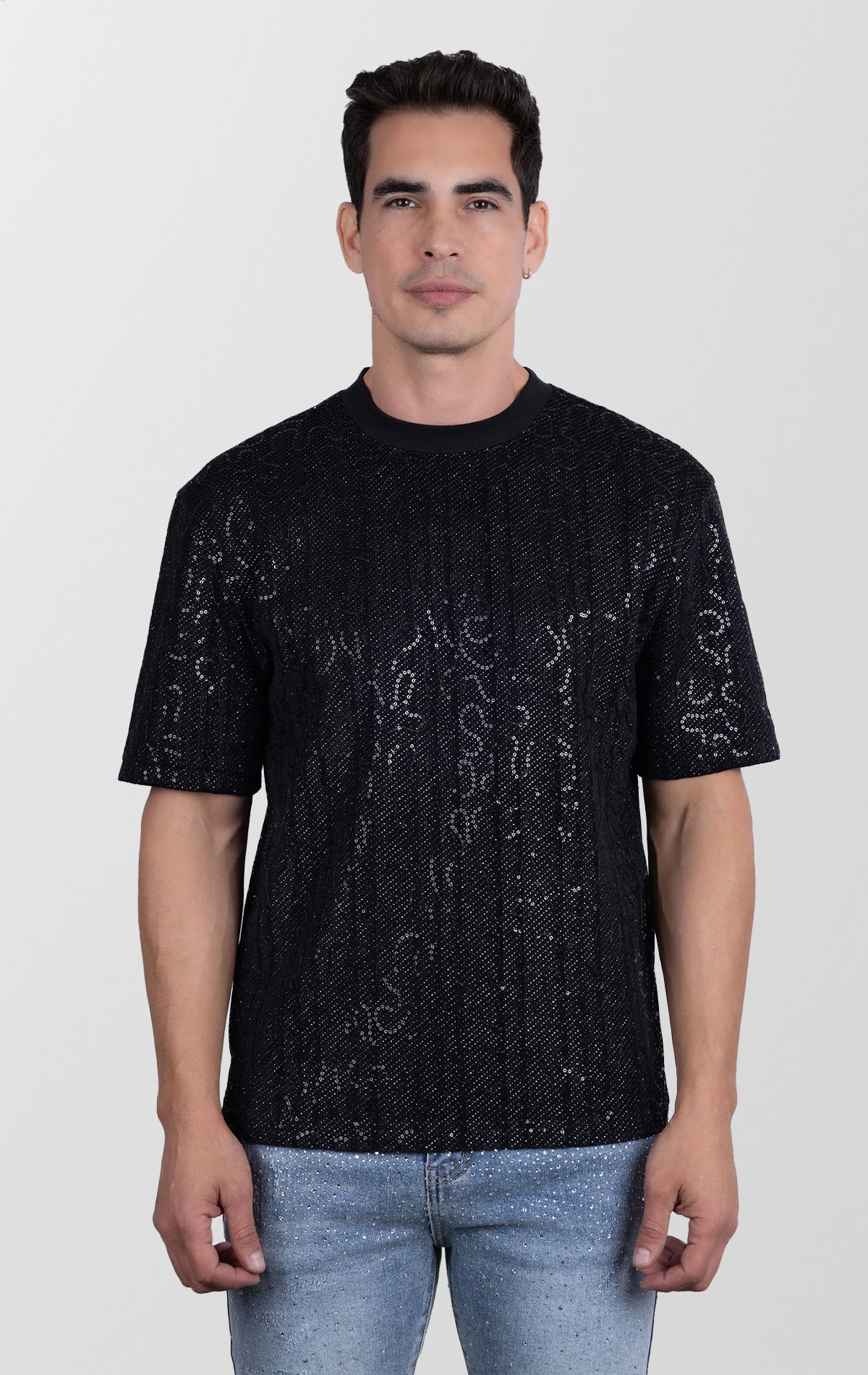 Man wearing a black textured t-shirt against a white background