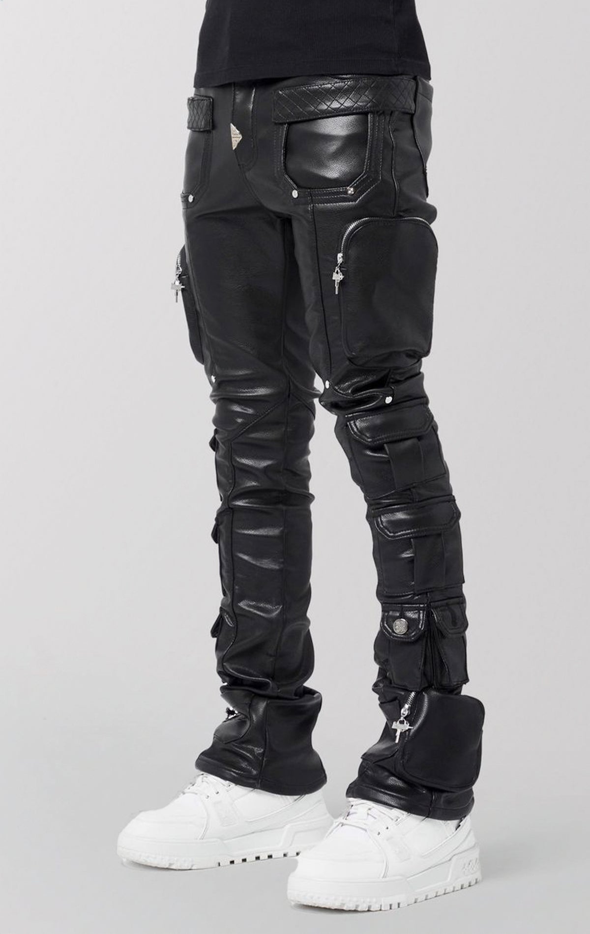Black leather pants with unique design elements on a gray background