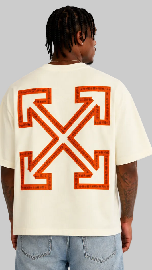 A man modeling an oversized cream-colored t-shirt, the back features a large orange crossed arrows logo.