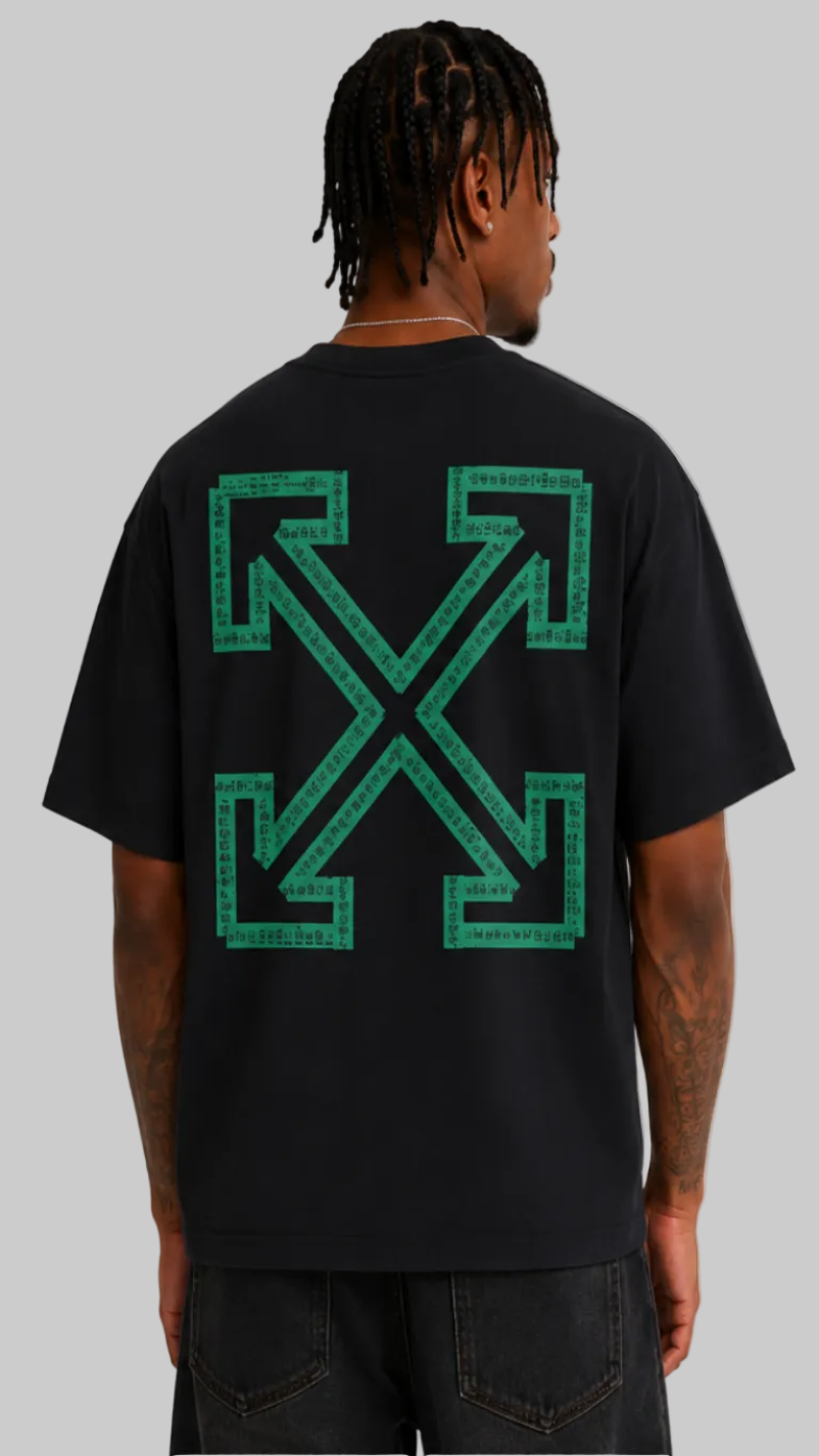A man viewed from the back wearing a black t-shirt with a large green Off-White cross-arrows logo printed on the back, paired with dark gray jeans against a light gray studio background.