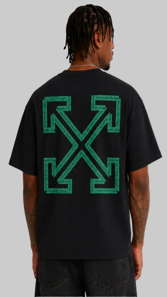 A man viewed from the back wearing a black t-shirt with a large green Off-White cross-arrows logo printed on the back, paired with dark gray jeans against a light gray studio background.