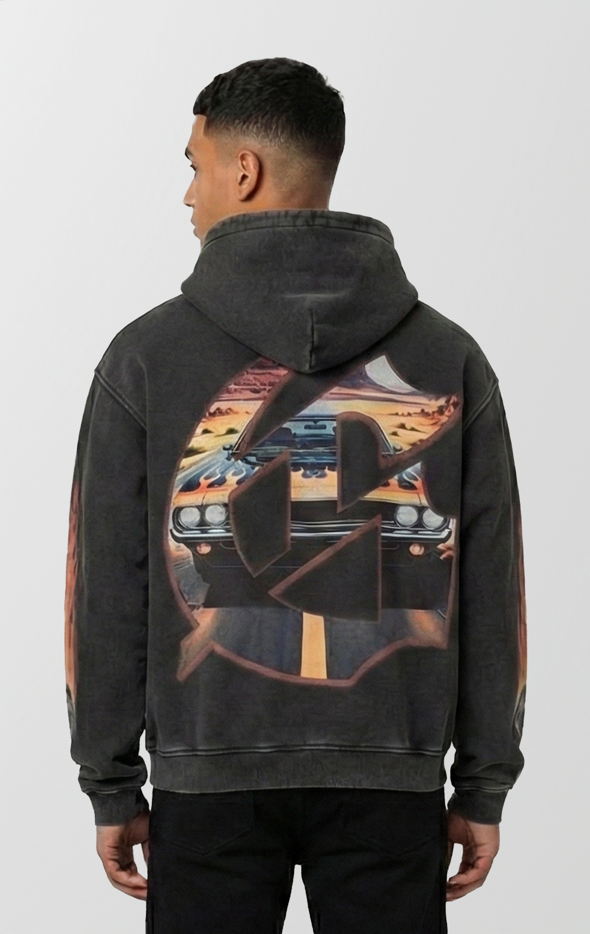 Vintage black wash Godspeed hoodie featuring a POV graphic of a cracked windshield, red fuzzy dice, and a muscle car on a desert highway. Sleeves feature flame and tire designs, and the back has a large G logo with desert scenery fill.