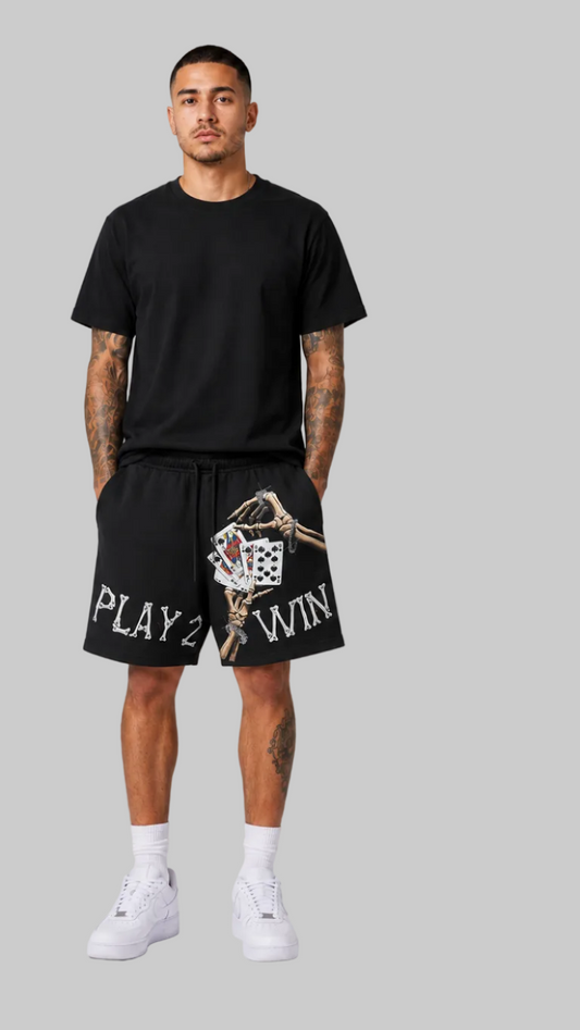man modeling a black short-sleeve t-shirt and black shorts. The front view shows the shorts with a graphic of playing cards and the text 'PLAY 2 WIN'