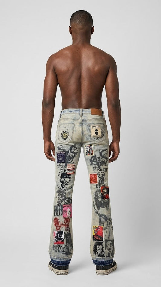 A shirtless male model viewed from the back wearing heavily distressed light-wash jeans covered with graphic patches, stickers, and graffiti-style prints, against a light gray studio background.