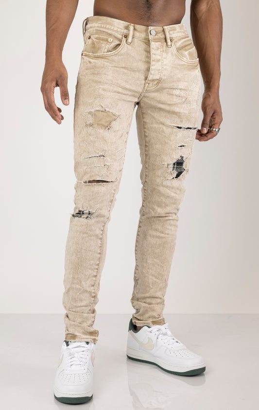 Beige Skinny Jeans with a contrasting plaid patch. Made from 98% cotton and 2% lycra. Features include a signature purple hangtag, lined back pockets and yoke for comfort and shape retention, reinforced belt loops, hidden back pocket rivets, and a classic button fly closure.  Please note: Due to the individual hand-finishing process, slight variations may occur, making each pair one-of-a-kind.