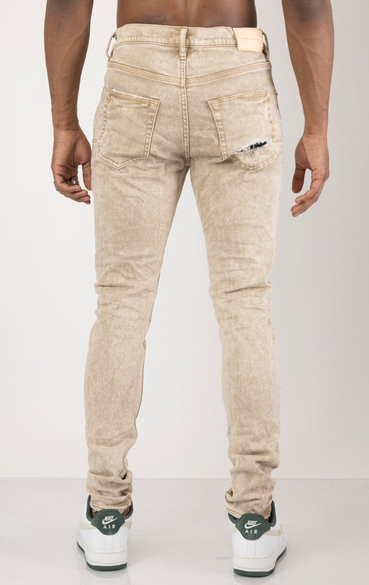 Beige Skinny Jeans with a contrasting plaid patch. Made from 98% cotton and 2% lycra. Features include a signature purple hangtag, lined back pockets and yoke for comfort and shape retention, reinforced belt loops, hidden back pocket rivets, and a classic button fly closure.  Please note: Due to the individual hand-finishing process, slight variations may occur, making each pair one-of-a-kind.