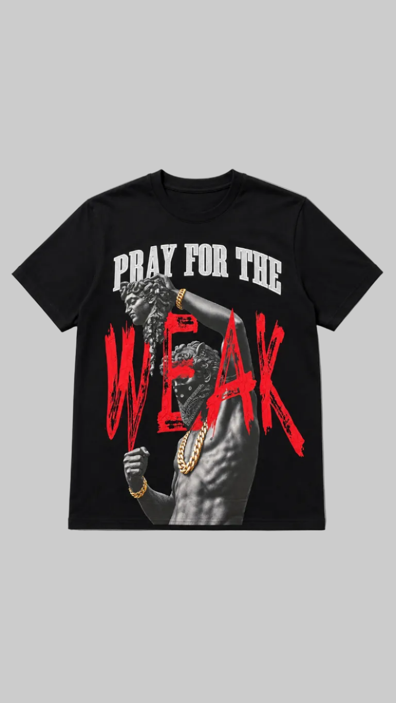 A black short-sleeve graphic t-shirt featuring a printed design of a muscular male statue with gold jewelry, overlaid with the text 'PRAY FOR THE WEAK' in white and distressed red lettering, shown on a neutral gray background.