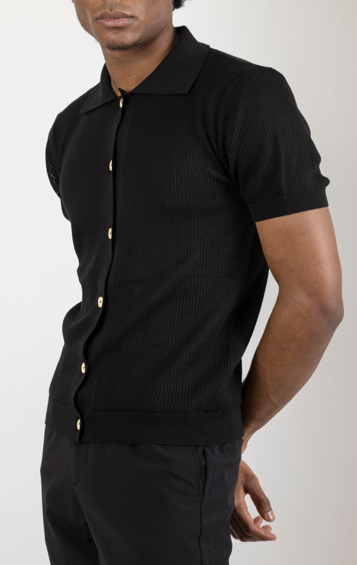 Men's see-through button-down mesh top in black. The top is made from a 50% cotton, 50% acrylic blend and features a tailored fit with a sheer mesh fabric and button-down closure.