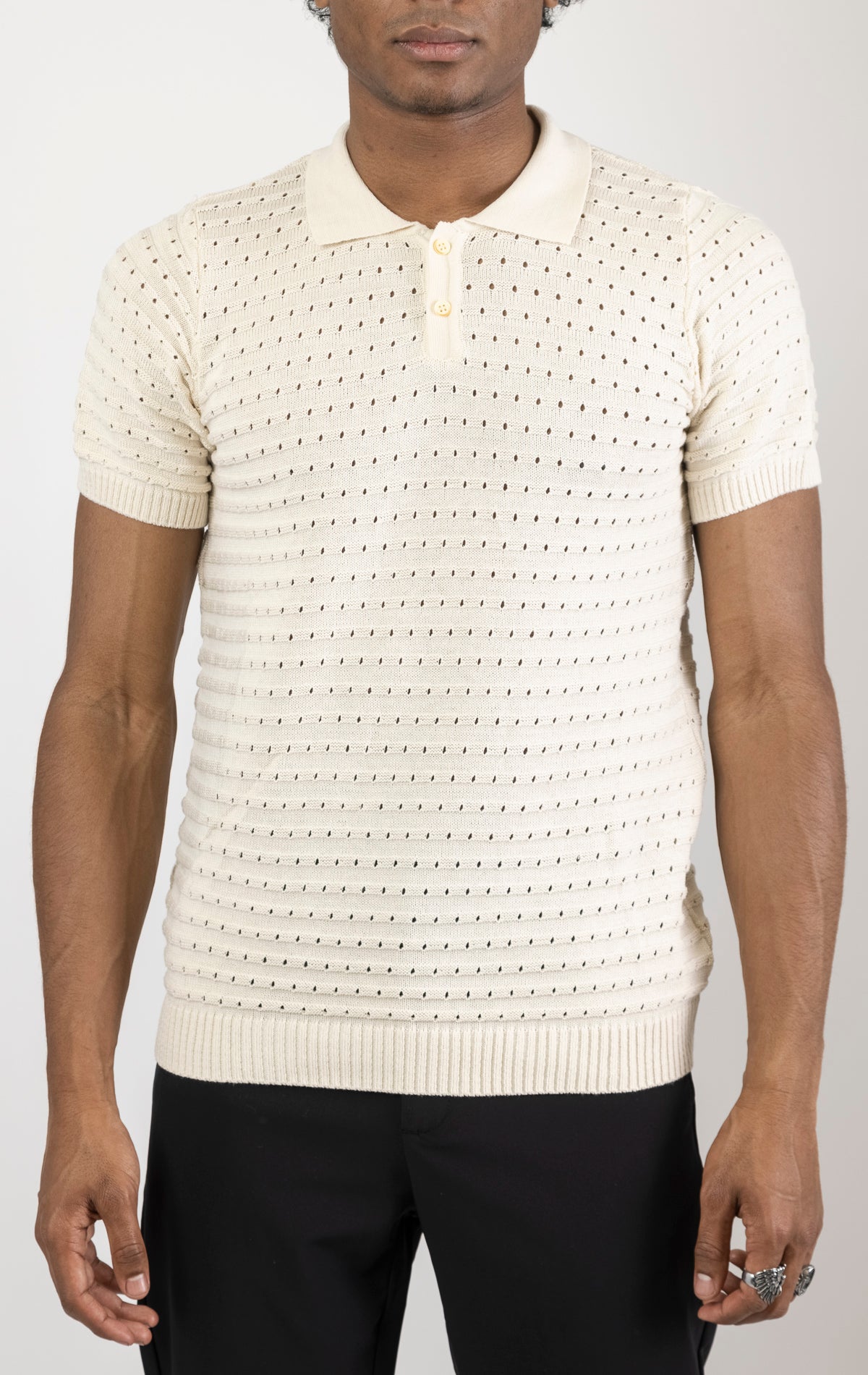 Men's eyelet short sleeve polo tee in Beige. The shirt is made from a soft and breathable fabric (50% viscose, 50% polyamide) and features a classic polo collar, short sleeves, and delicate eyelet detailing along the sleeves.