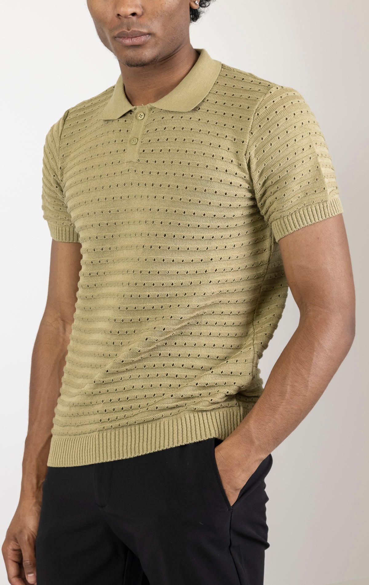 Men's eyelet short sleeve polo tee in light green. The shirt is made from a soft and breathable fabric (50% viscose, 50% polyamide) and features a classic polo collar, short sleeves, and delicate eyelet detailing along the sleeves.