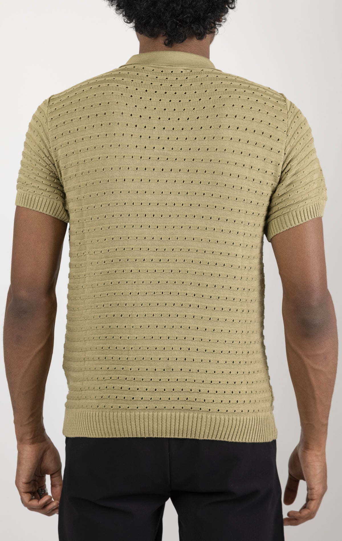 Men's eyelet short sleeve polo tee in light green. The shirt is made from a soft and breathable fabric (50% viscose, 50% polyamide) and features a classic polo collar, short sleeves, and delicate eyelet detailing along the sleeves.